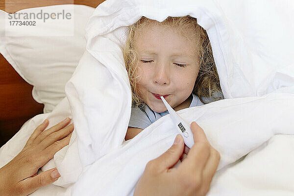 Kranke Tochter vermeidet die Benutzung des Thermometers durch die Mutter im Schlafzimmer