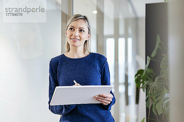 Geschäftsfrau mit digitalem Tablet im Bürodenken