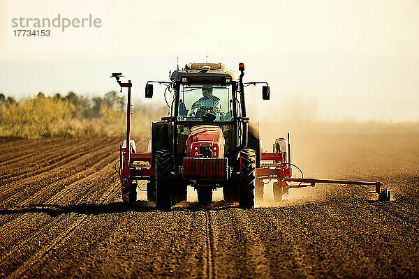 Landwirt im Traktor sät Sojabohnen bei der Arbeit auf dem Feld