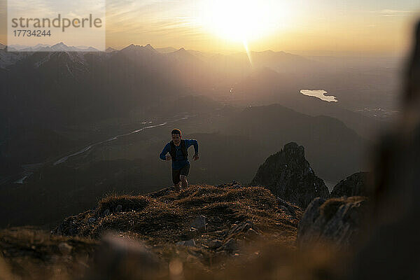 Mann wandert bei Sonnenuntergang auf dem Sauling-Berg