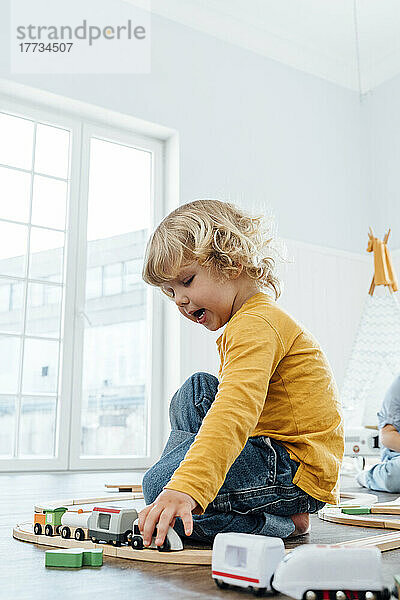Junge spielt zu Hause mit Spielzeugeisenbahn