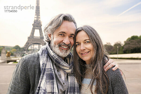 Lächelnder reifer Mann mit Arm um Frau vor Eiffelturm  Paris  Frankreich