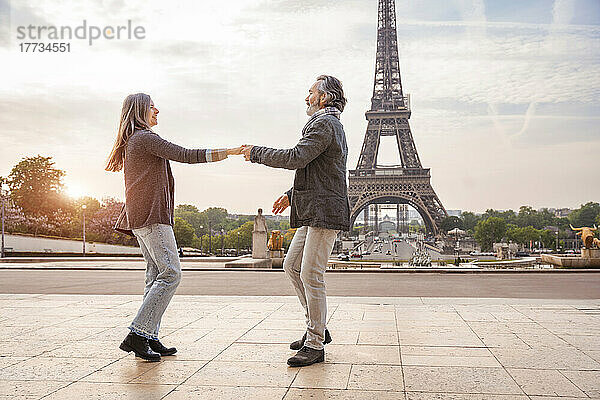Glücklicher reifer Mann mit tanzender Frau vor dem Eiffelturm  Paris  Frankreich