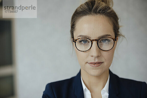 Selbstbewusste Geschäftsfrau mit Brille im Büro