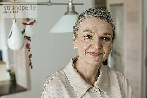 Porträt einer selbstbewussten reifen Frau mit kurzen grauen Haaren zu Hause