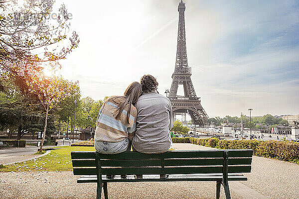 Älteres Paar sitzt zusammen auf einer Bank vor dem Eiffelturm  Paris  Frankreich