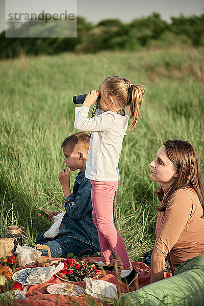 Mutter und Kinder beim Picknick im landwirtschaftlichen Bereich