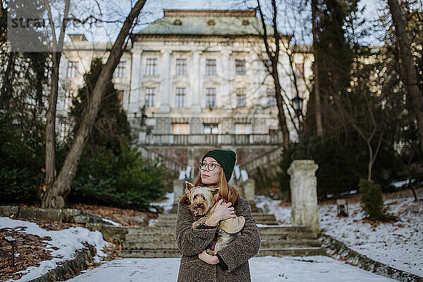 Frau mit Yorkshire Terrier steht vor dem Gebäude