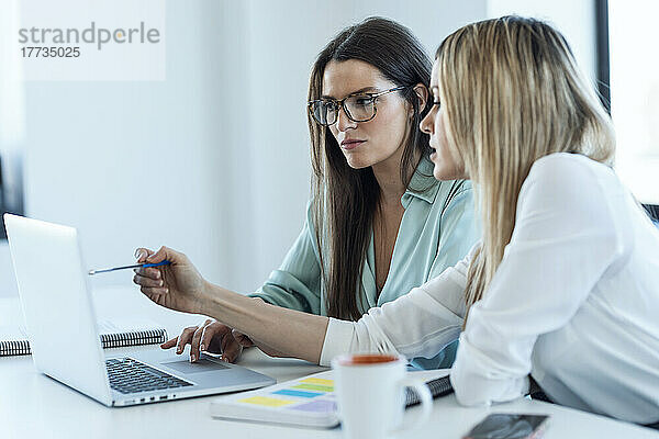 Geschäftsfrauen diskutieren am Laptop am Schreibtisch im Büro