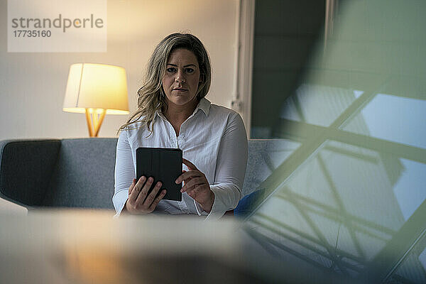 Selbstbewusste Geschäftsfrau mit Tablet-PC im Büro