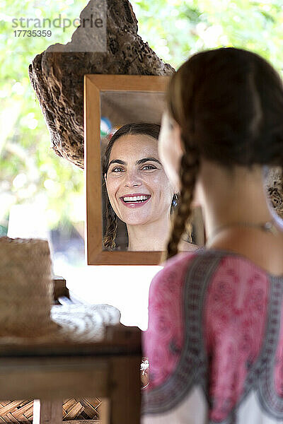 Smiling woman looking in mirror