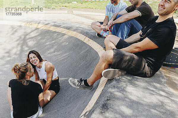 Fröhliche Freunde genießen im Skateboardpark