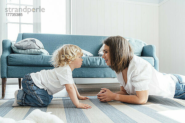 Mutter und Sohn starren sich zu Hause auf dem Sofa im Wohnzimmer an