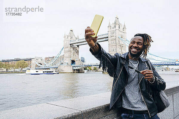 Glücklicher Mann macht ein Selfie mit dem Smartphone an der Themse  London  England