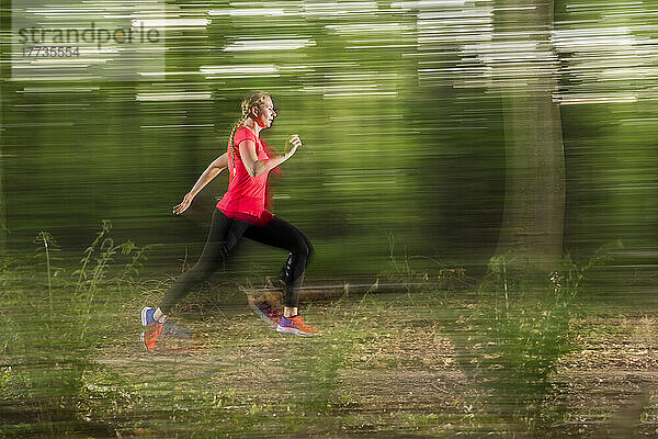Young woman running in forest