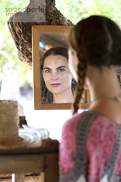 Selbstbewusste Frau  die sich selbst im Spiegel betrachtet
