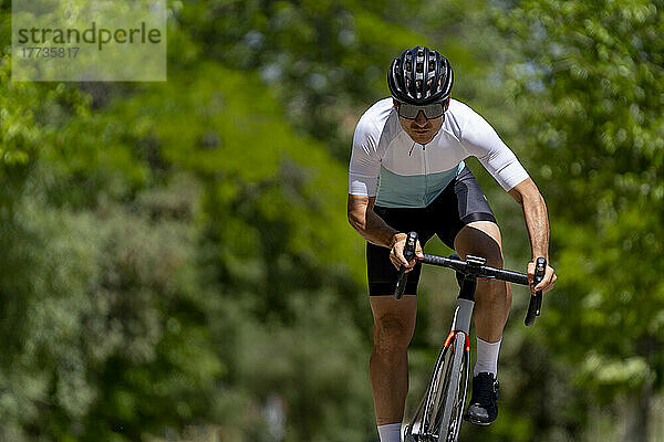 Engagierter reifer Sportler  der an einem sonnigen Tag Fahrrad fährt