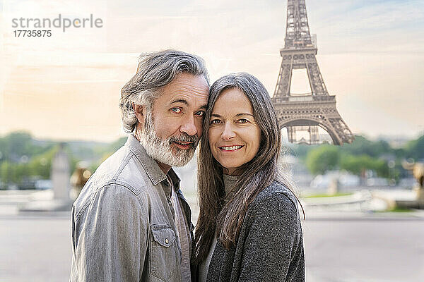 Lächelnde Frau und Mann stehen vor dem Eiffelturm  Paris  Frankreich