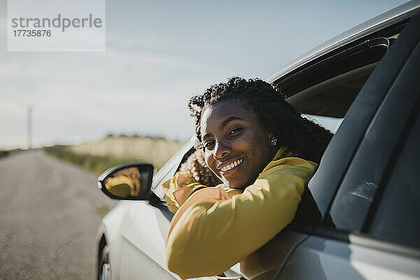 Lächelnde Frau  die aus dem Autofenster schaut