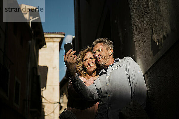 Älteres Paar macht an einem sonnigen Tag ein Selfie mit dem Handy