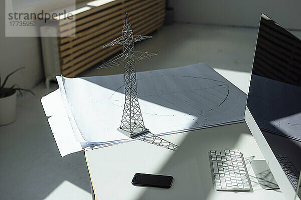 Strommastmodell und Bauplan auf dem Schreibtisch