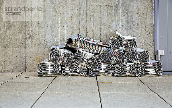 Zeitungsstapel liegen vor einem Wohnhaus