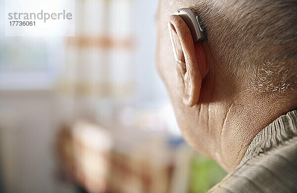 Ohr eines älteren Mannes mit Hörgerät