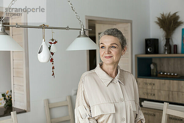 Confident mature woman with short grey hair at home