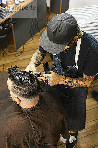 Friseur schneidet dem Kunden im Salon Haare