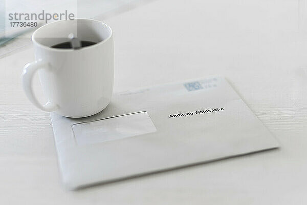 Briefumschlag mit Kaffeetasse auf dem Tisch