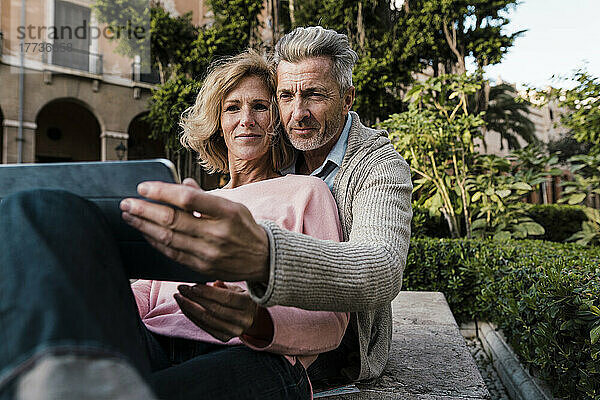 Älteres Paar benutzt Tablet-Computer im Park