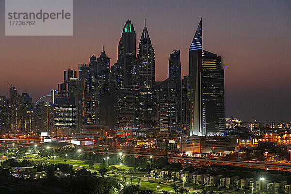 Vereinigte Arabische Emirate  Dubai  beleuchteter Golfplatz bei Nacht mit den Jumeirah Lakes Towers im Hintergrund