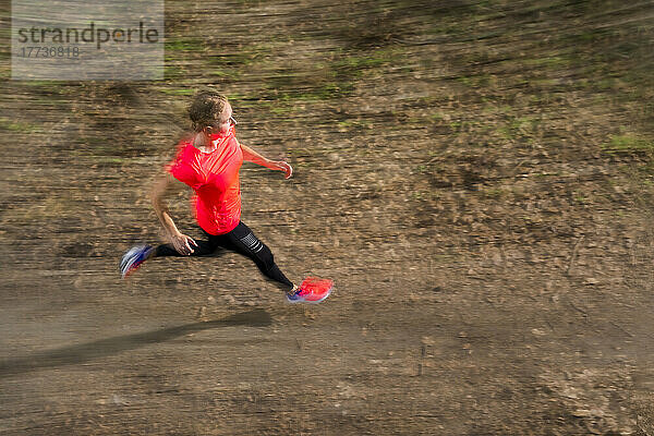 Young woman running on dirt road