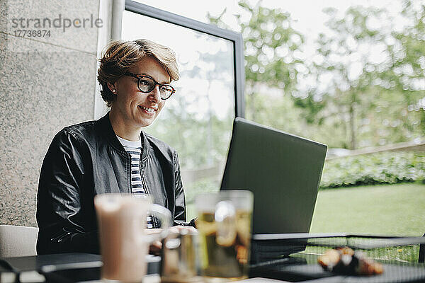 Geschäftsfrau arbeitet am Laptop und sitzt im Café