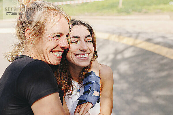 Glückliche Frau umarmt Freundin im Skateboardpark