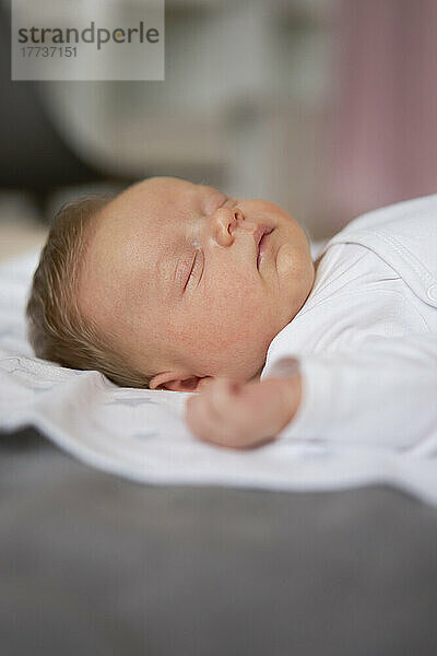 Cute baby boy sleeping on bed at home