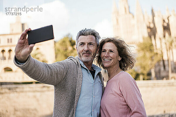 Lächelnder Mann macht Selfie mit Frau in der Stadt