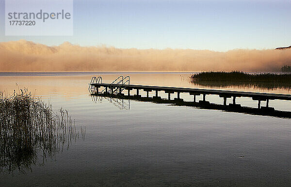 Austria  Upper Austria  Bathing jetty on shore of Mondsee lake with thick morning fog in background