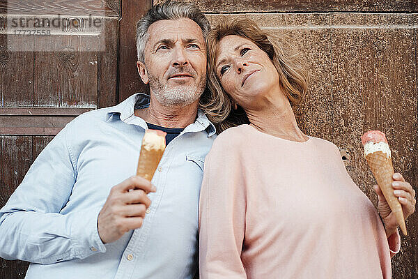 Nachdenkliches älteres Paar mit Eis vor der Tür