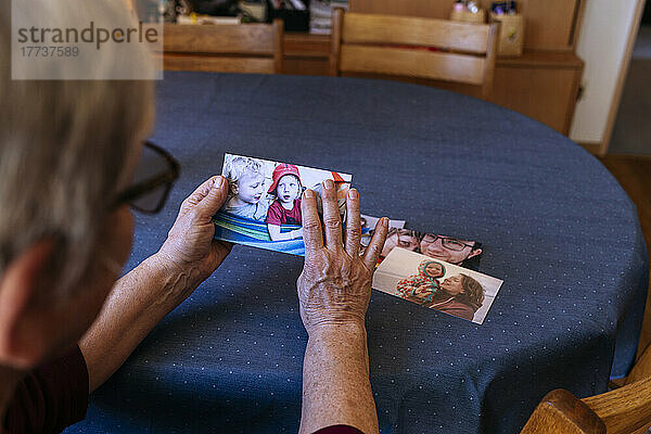 Senior woman with photographs of family at home