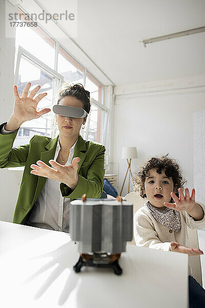 Mutter und Tochter erkunden die High-Tech-Entwicklung des Metaversums mithilfe eines Virtual-Reality-Simulators