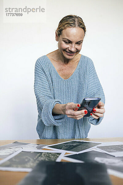 Lächelnde Frau  die Fotos mit dem Smartphone fotografiert