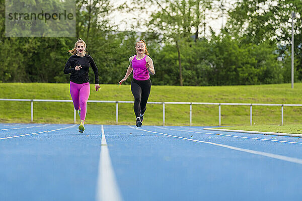 Young sportswomen running on sports track