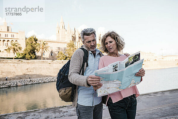 Reife Touristen lesen im Urlaub eine Karte in der Stadt