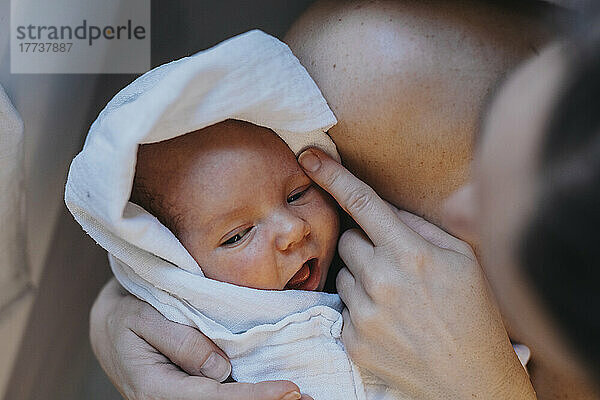 Mother holding baby wrapped in towel