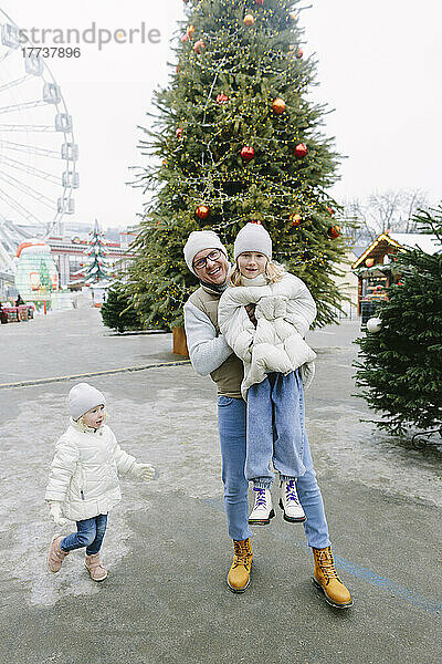 Glücklicher Vater holt Tochter auf dem Weihnachtsmarkt ab