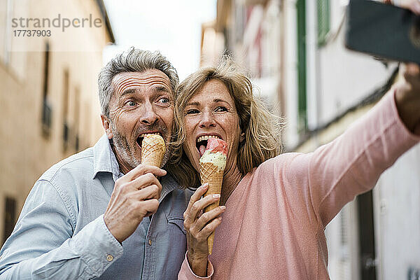 Fröhliche Touristen  die Eis essen und ein Selfie mit dem Smartphone machen