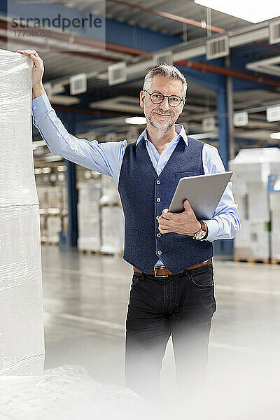 Lächelnder Manager mit Tablet-PC im Lager