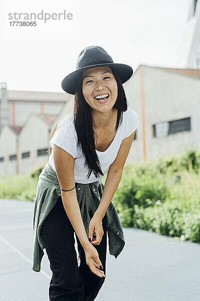 Cheerful young woman wearing hat enjoying on sunny day