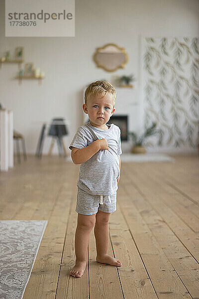 Boy standing on hardwood floor at home
